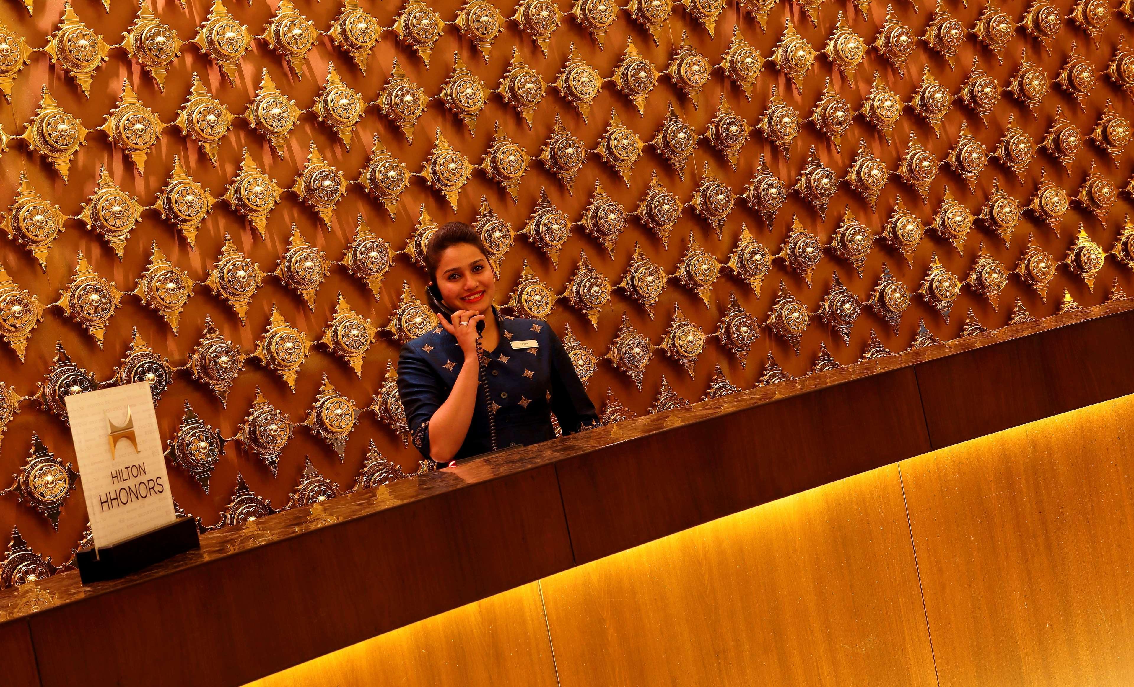 Hilton Jaipur Hotel Luaran gambar A hotel receptionist at work